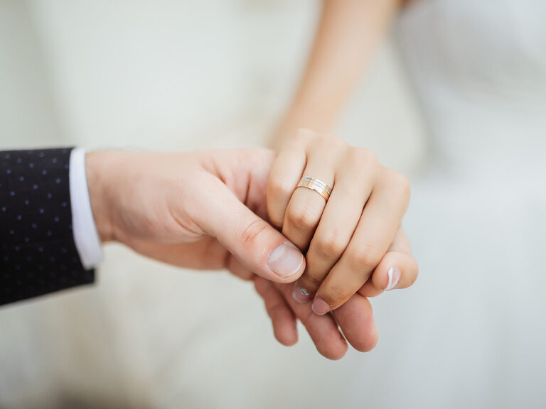 Zwei Hände mit Eheringen – frisch verheiratetes Paar
