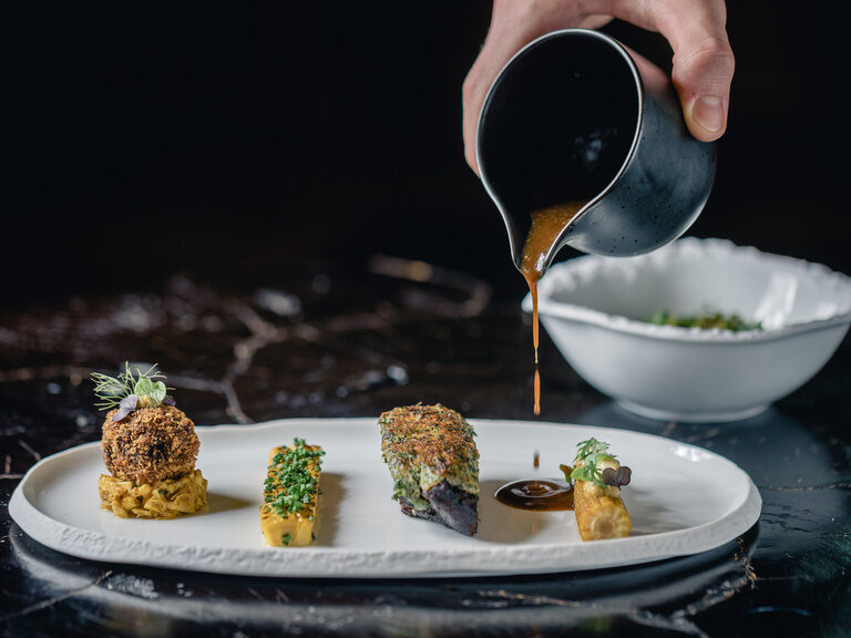 Anrichtemoment im Restaurant Maerz – Sauce wird über Sternegericht gegossen